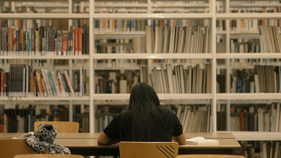 Imatge noia d'esquena en una biblioteca