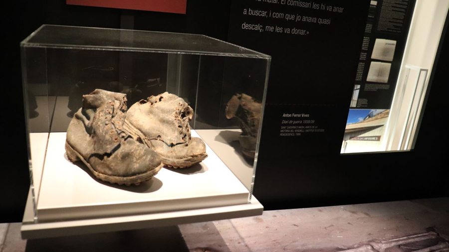Vitrina de l'exposició amb les restes d'unes botes recuperades en els treballs d'exhumació.