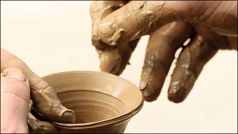 Mans treballant argila