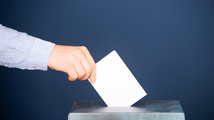 Persona posant un vot en una urna